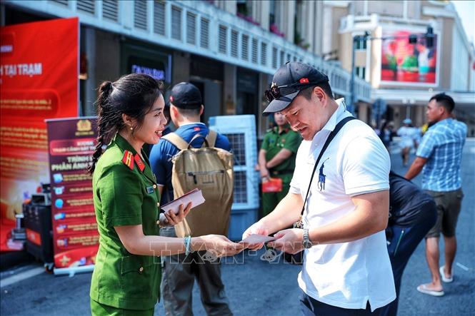 Cán bộ Công an giới thiệu, hướng dẫn người dân tìm hiểu các tiện ích của mô hình Kiosk “Trạm Cảnh sát thông minh”. (Ảnh: Phạm Tuấn Anh/TTXVN)